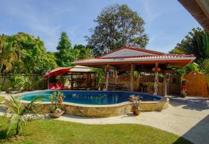 班佩Tina's Living Paradise - Guesthouses with private pool的一个带凉亭的庭院内的游泳池