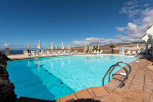 阿马多雷斯阿马多雷斯花园俱乐部假日酒店的一个带椅子的大型游泳池,并享有海景