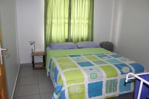 帕拉马里博瑞秋公寓式酒店的一间卧室配有一张带绿帘的床