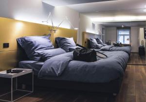 施韦比施哈尔施洛酒店的一间设有三张床和蓝色枕头的客房