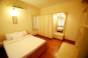 班加罗尔Falcon Suites Residency Road的一间小卧室,配有白色的床和窗户