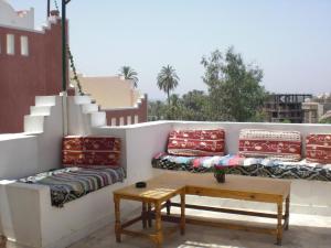 卢克索艾尔法洛兹酒店的阳台配有沙发、桌子和楼梯。