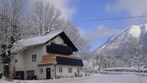 拉肯霍夫Haus-am-Sonnenweg的一座雪覆盖的房子,背景是一座山