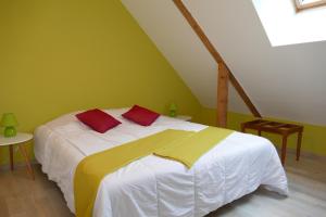 安锡la ferme du parroi的一间卧室配有白色的床和红色和黄色枕头