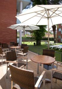 卡斯特尔德费尔斯SG科斯塔巴塞罗那公寓式酒店的一个带桌椅和遮阳伞的庭院