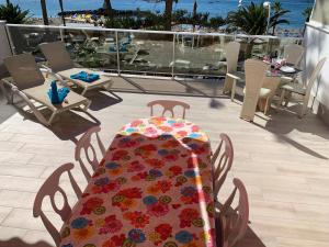 阿罗纳Los Cristianos Best Beach View的阳台上一张桌子,上面有五颜六色的桌布