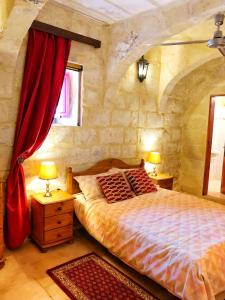 阿尔卜Molendini的一间卧室配有一张带红色窗帘的大床