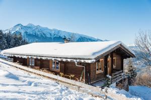 布肯Ropferhof的小木屋,被雪覆盖,背景是群山