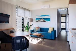 巴利纳Reflections Shaws Bay - Holiday Park的客厅配有蓝色的沙发和桌子