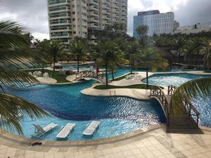里约热内卢Apartamento Bora Bora的度假村设有2个带椅子和棕榈树的游泳池