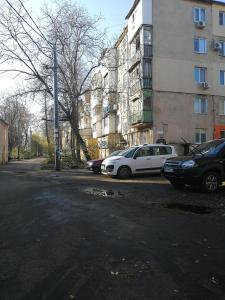 敖德萨Апартаменты на Ивана и Юрия Лип的两辆汽车停在大楼旁边的停车场