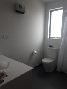 提马鲁诺斯帕克汽车旅馆的白色的浴室设有卫生间和窗户。