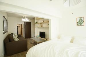 东京Roppongi WoodsHouse501的一间卧室配有一张床、一张沙发和一台电视