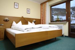 索尔登安德里亚斯酒店的一间卧室配有一张带白色床单的床和一扇窗户。