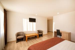 陶格夫匹尔斯比普兰酒店的卧室配有一张床和一张桌子及椅子