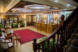 撒马尔罕Hotel Grand Samarkand Superior - B的一间房间,设有楼梯和红色地毯