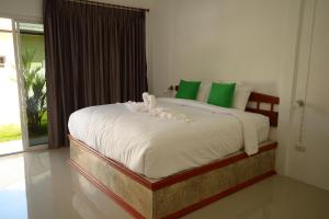蔻立Mrchu Meditation House的一间卧室配有一张带绿色和白色枕头的大床
