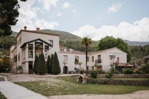 阿尔科伊Eco Hotel con encanto Masía la Mota B&B的一座白色的大房子,前面有一棵棕榈树