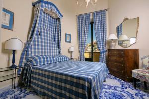 波西塔诺玛格丽塔宫酒店的一间蓝色和白色的卧室,配有一张床和一个梳妆台