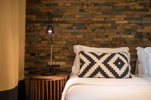 圣多美圣多美欧马里酒店 的一间卧室设有一张床和砖墙