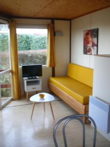 米尔普瓦三剑客小屋酒店的小房间设有黄色的沙发和桌子