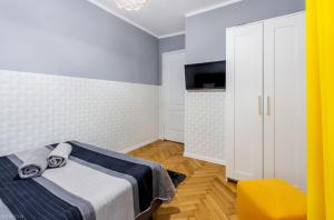 华沙ClickTheFlat Żurawia Street Apart Rooms的一间带床和电视的小卧室