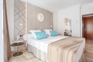 穆罗海滩Grupotel Los Príncipes & Spa的卧室配有带蓝色枕头的大型白色床