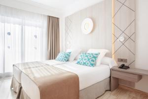 穆罗海滩Grupotel Los Príncipes & Spa的卧室配有带蓝色枕头的大型白色床