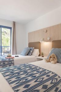克罗姆港皮埃尔马略卡赛西利亚公寓酒店的酒店客房设有两张床,上面有泰迪熊