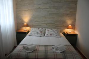 ArieiroPro Touristic Montejunto Villas的一间卧室配有一张带两个枕头和两个灯的床。