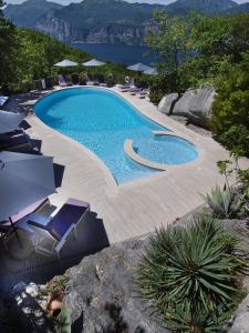 马尔切西内Hotel Querceto Wellness & Spa - Garda Lake Collection的一个带椅子的大型游泳池,享有水景