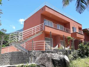 伊利亚贝拉Suítes Cambucá的前面有楼梯的红色建筑