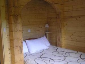 威廉堡Chalet Blaich的木制客房内的一间卧室,配有一张床
