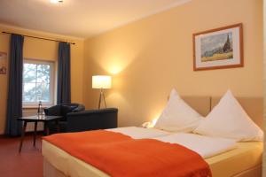 格拉尔-米里茨Hotel Villa Strandkorb的酒店的客房 - 带一张床、椅子和窗户