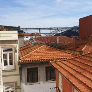 波尔图Lux Ribeira - ALL INCLUDED的背景中桥梁建筑屋顶的景色