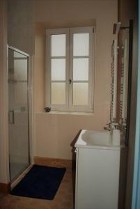 博讷Les Cimaises du Couvent的一间带水槽和玻璃淋浴的浴室