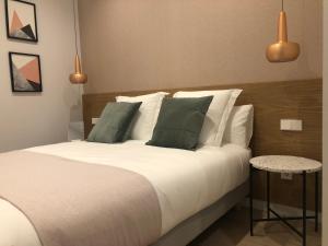 圣塞瓦斯蒂安MARCIAL SUITE Central, modern and NEW.的一间卧室配有带白色床单和绿色枕头的床。
