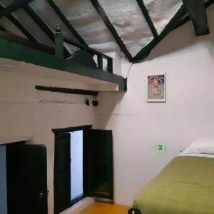 波哥大Cedron Hostel的一间卧室配有一张床和一张绿色双层床
