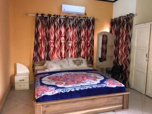SunyaniNass Lodge的一间卧室配有一张带天蓬和窗帘的床
