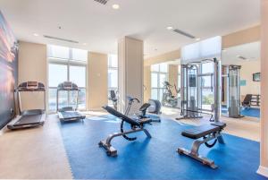 彭萨科拉海滩The Pensacola Beach Resort的健身房设有数台跑步机和有氧运动器材