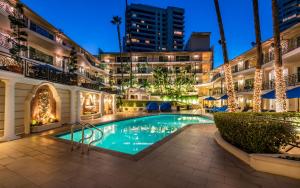 洛杉矶Beverly Hills Plaza Hotel & Spa的一座建筑物中央的游泳池