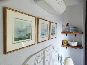 莫特拉下城区La Casetta的走廊上墙上有四张照片,墙上有椅子
