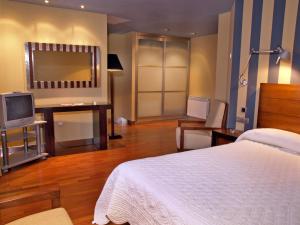 阿韦哈尔冷水河旅馆的卧室配有白色的床和电视。