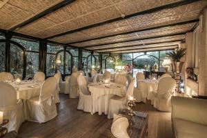 马里纳迪马萨马雷蒙帝别墅酒店的宴会厅配有白色的桌椅