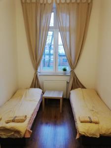 肯琴Apartament Parkowy的配有2张床的带窗户和桌子的客房