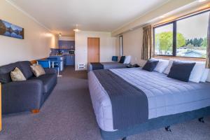 蒂阿瑙湖滨汽车旅馆公寓的一间卧室配有一张大床和一张沙发