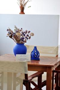 皮萨瑞弗罗达艾日达别墅公寓式酒店的一张桌子上放着蓝色花瓶和鲜花