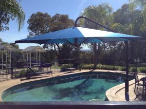 奥尔伯里商务高尔夫度假酒店的游泳池旁的蓝伞