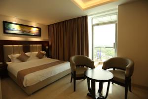 杰索尔The Zabeer Jashore的酒店客房设有床、桌子和窗户。