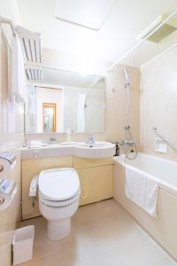 高知光明公园酒店的浴室配有卫生间、盥洗盆和浴缸。